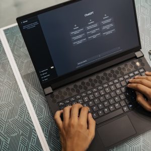 Person typing on a laptop with ChatGPT displayed, showcasing modern technology use.