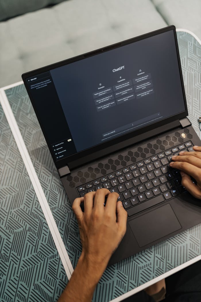 embark Person typing on a laptop with ChatGPT displayed, showcasing modern technology use.